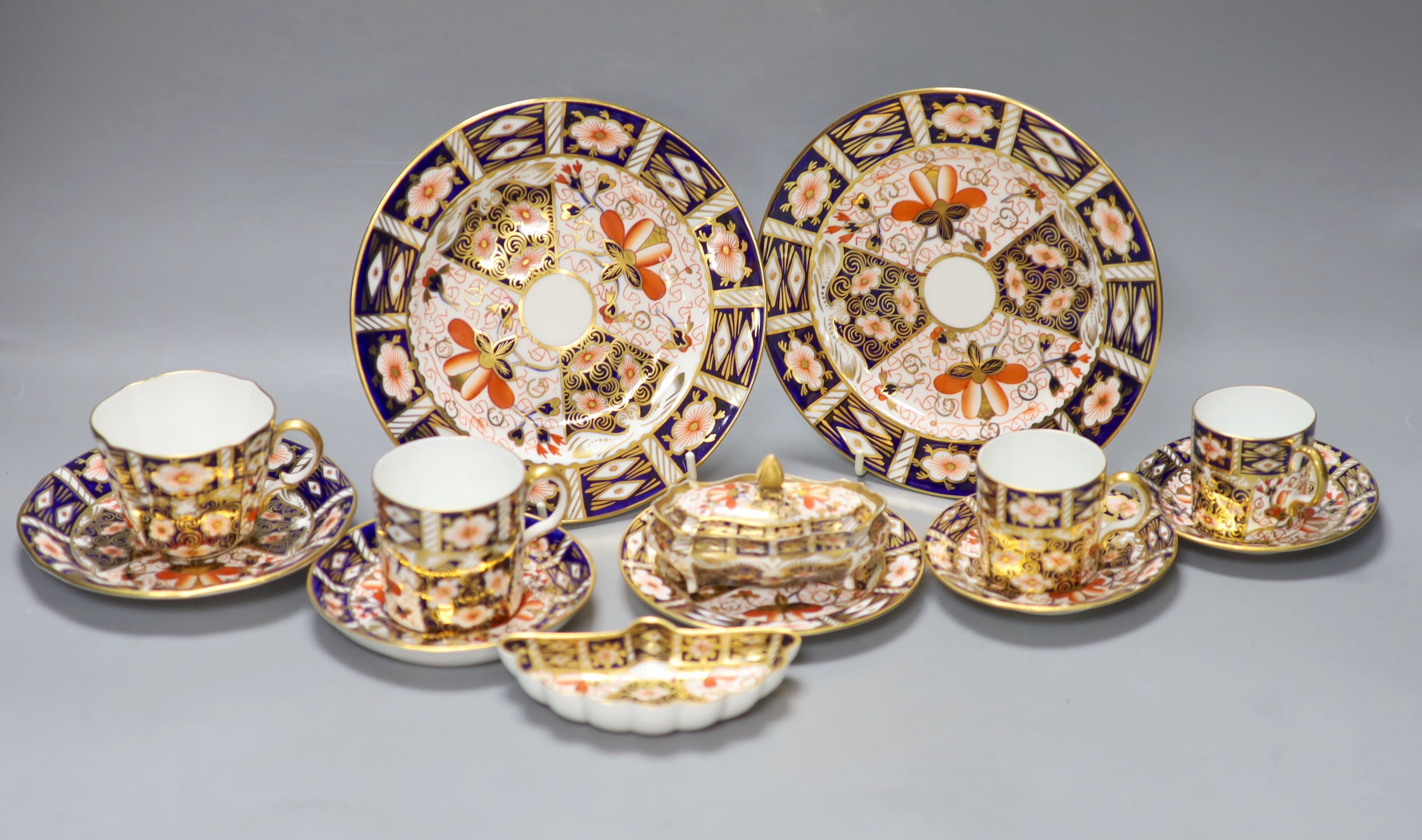 A Royal Crown Derby imari pattern 2451 cup and saucer, three cans and saucers, two bread plates, a small plate, a fan shaped dish and a